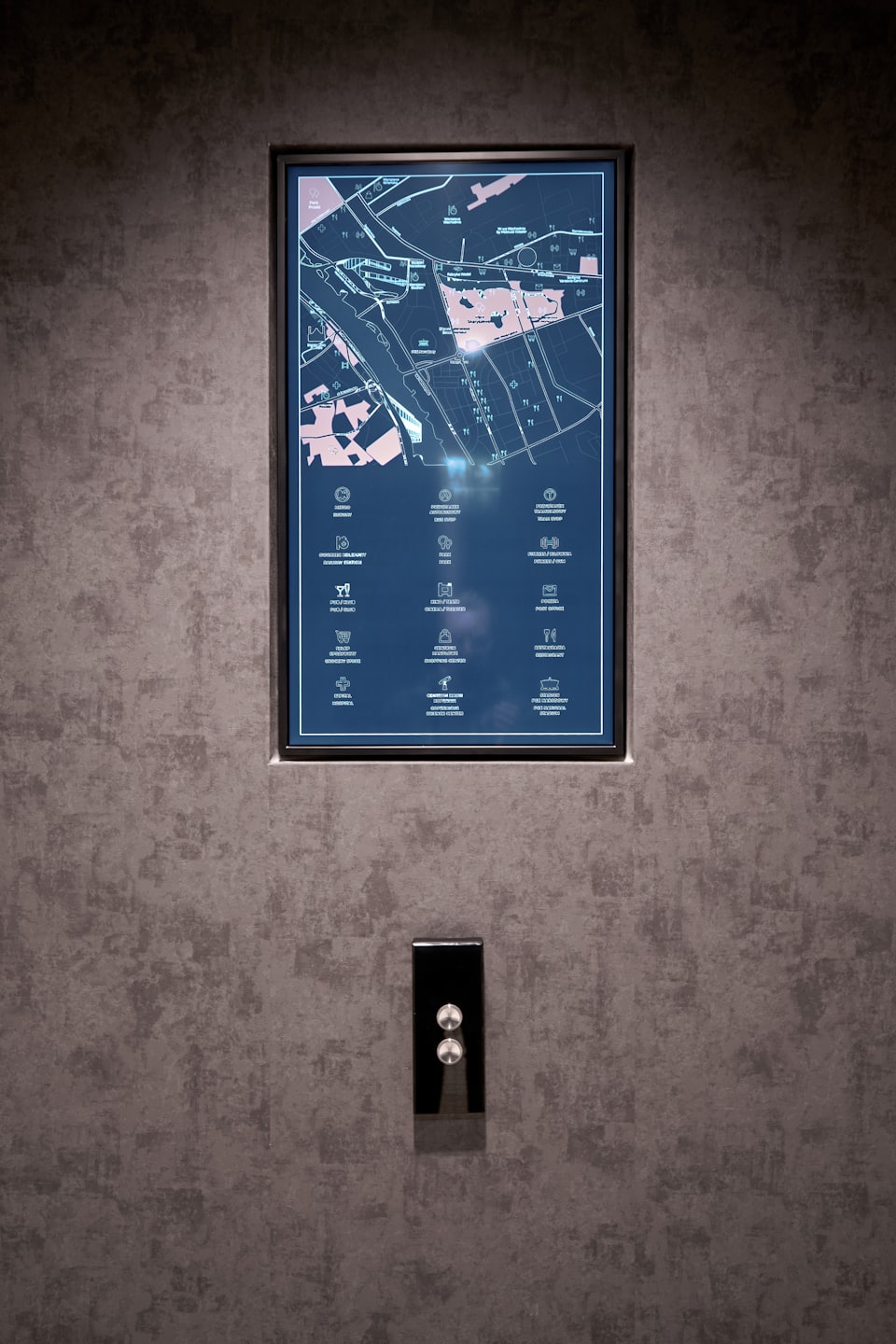 Mapa de directorio digital montado en una pared texturizada oscura.