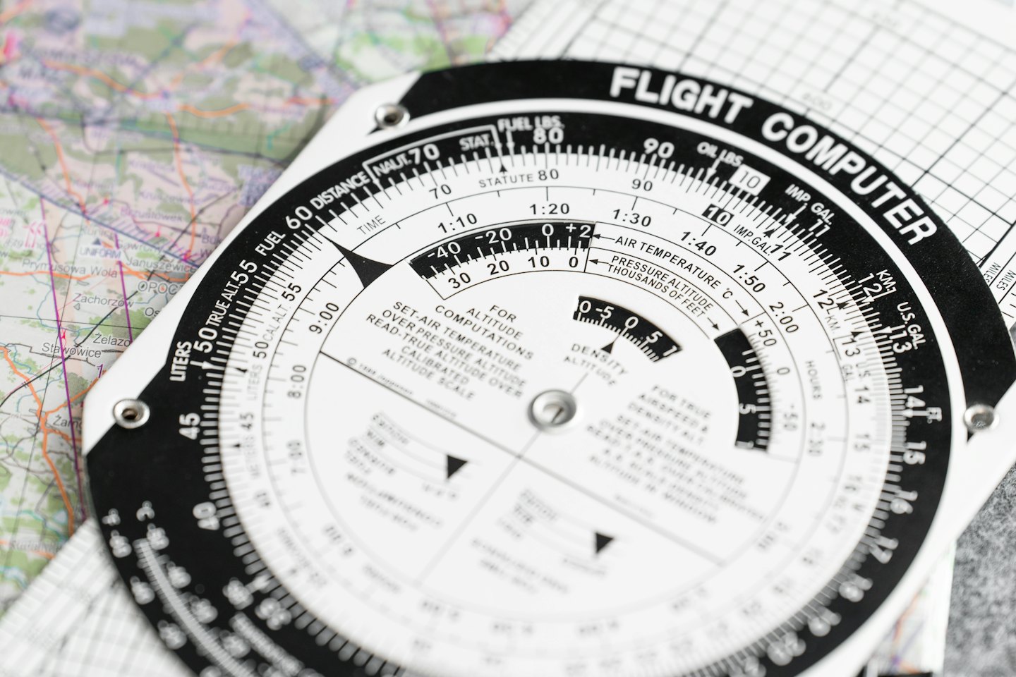 Un ordenador de vuelo de piloto descansando sobre un mapa de papel doblado.