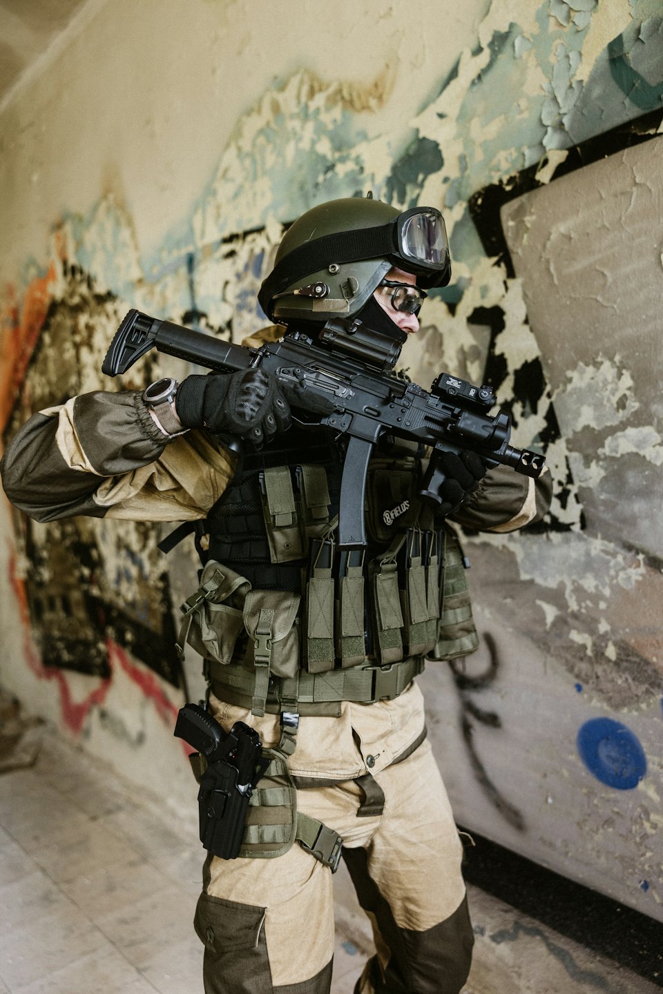 Oficial táctico con equipo completo porta un rifle en interiores.